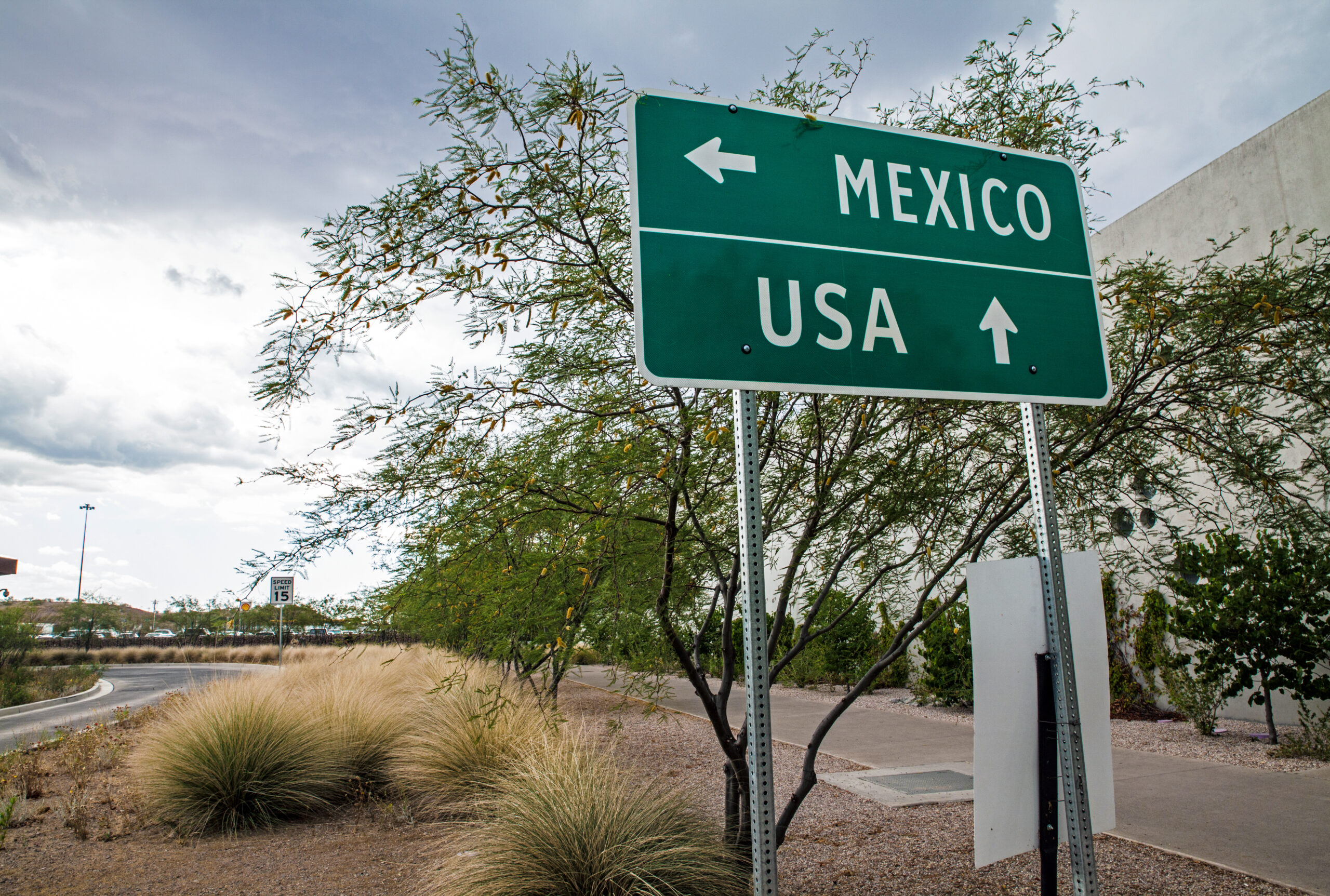 sign with arrows pointing to USA border and Mexico border to indicate where border crossing for people migrating from country