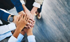 hands stacked on top of each other to represent community and team work at a personal injury law firm