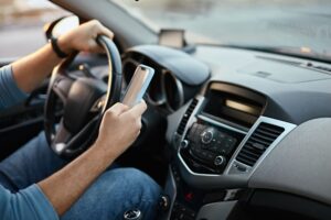 distracted driving by using phone which can lead to a California car accident and involve shared liability through comparative negligence