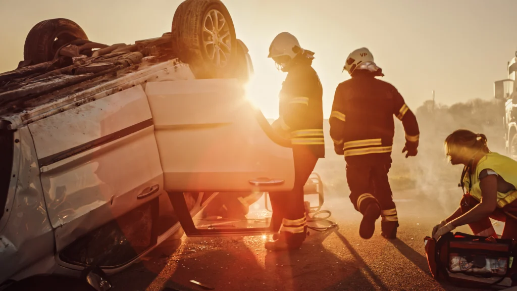Emergency responders arriving to an accident scene where a rollover accident occurred, resulting in serious injuries and ensuing damages, such as high medical bills, lost wages, and pain and suffering.